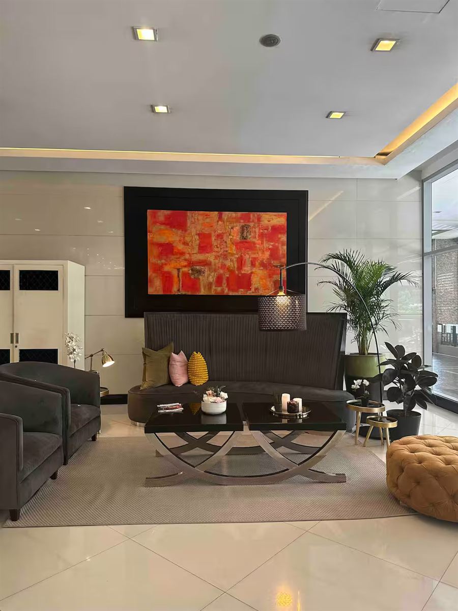 The Morgan Suites lobby with armchairs and a large abstract painting